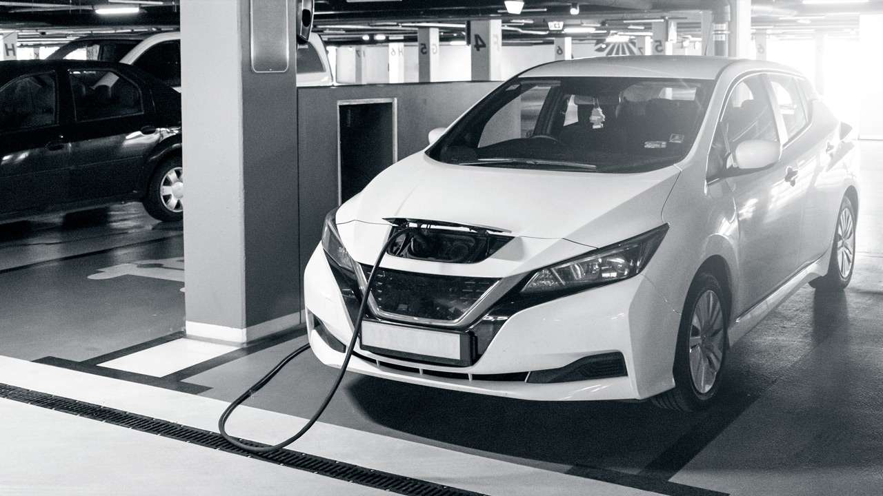 The electric car is plugged to get recharged at a e-charging station