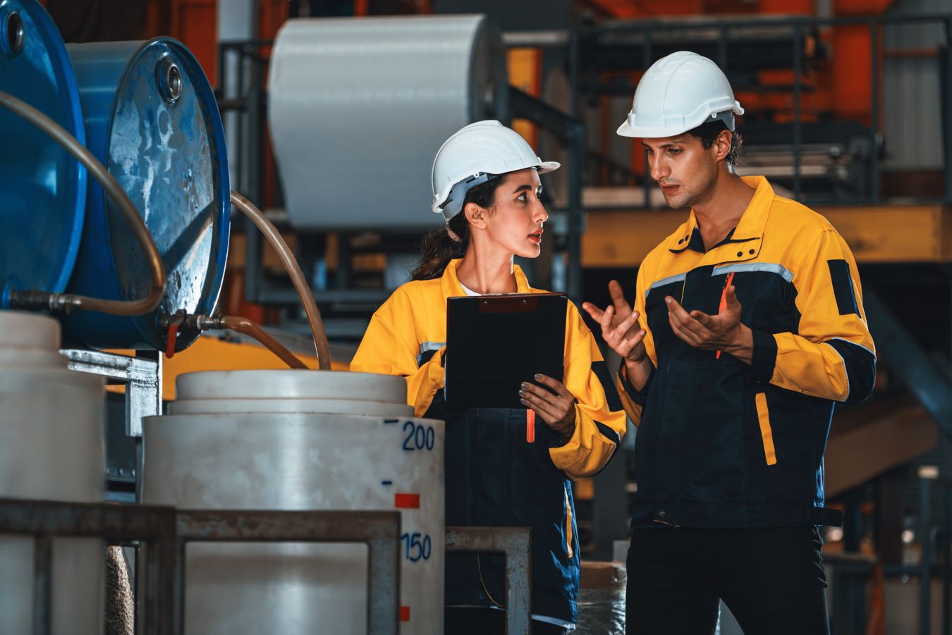 Industrial operators reviewing process equipment at a chemical processing facility supporting solvent filtration operations in a propane dehydrogenation (PDH) unit