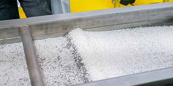 plastic recycling and clear polymer granules on a conveyor belt