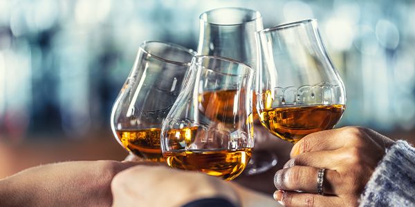 Activated carbon treatment integrated into spirits filtration to reduce unwanted flavor  and color active compounds