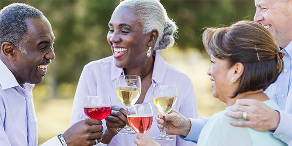 Group raising glasses of red, white, and rosé wine during an outdoor gathering